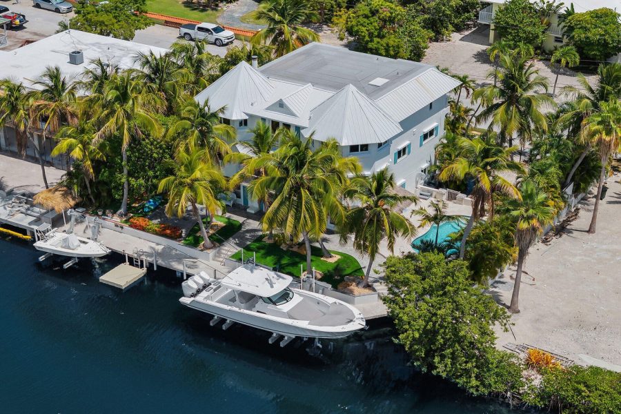 Canalfront home in Islamorada with two boats on the lift and a dock.