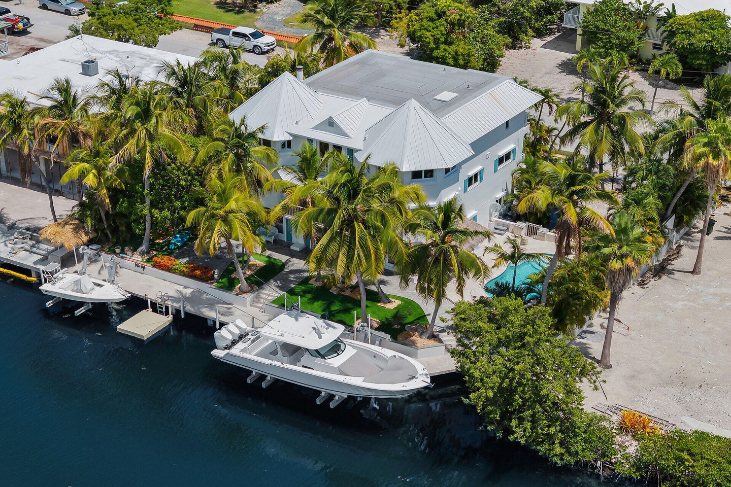 Canalfront home in Islamorada with two boats on the lift and a dock.